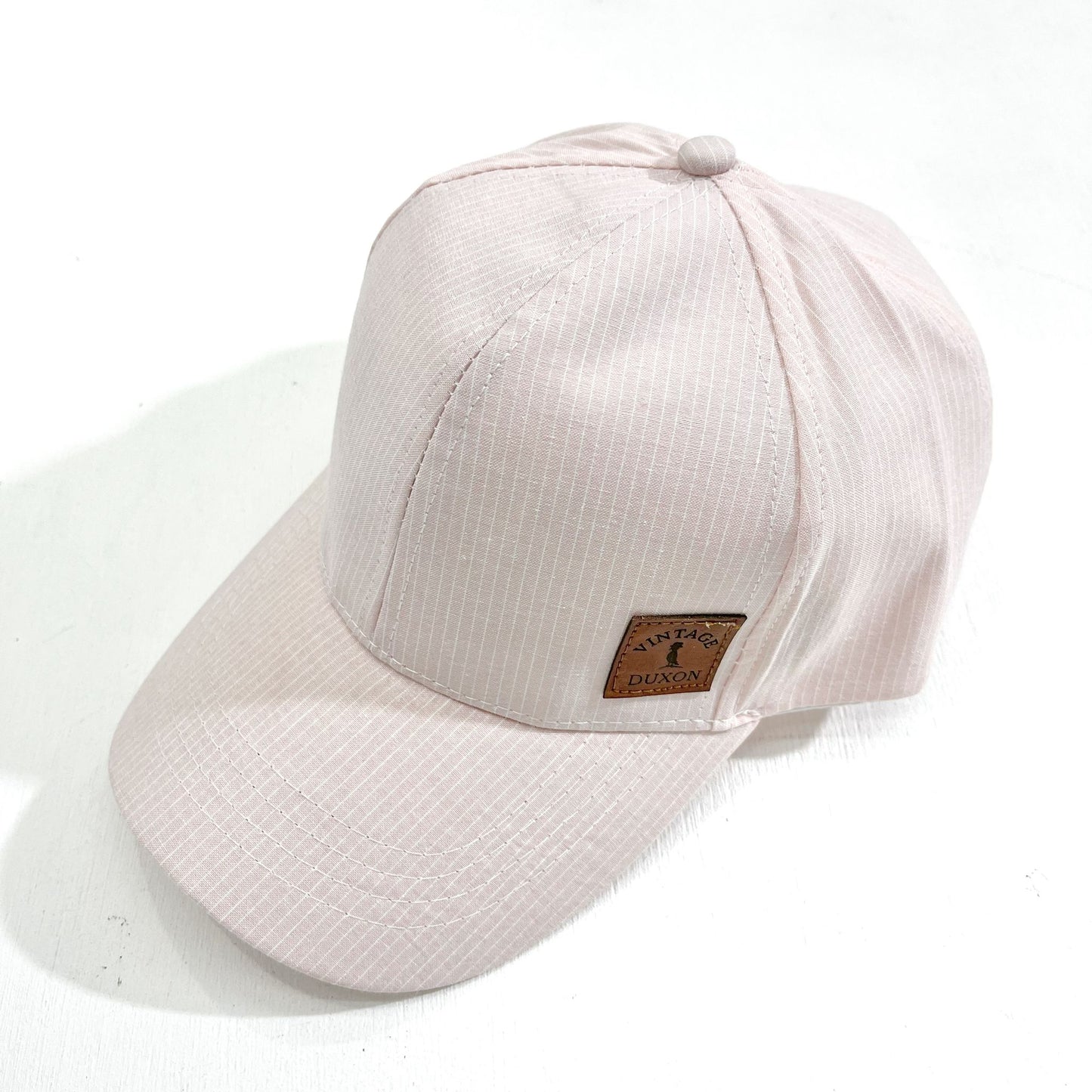 GORRA DE TELA CON VISERA A RAYAS ROSA