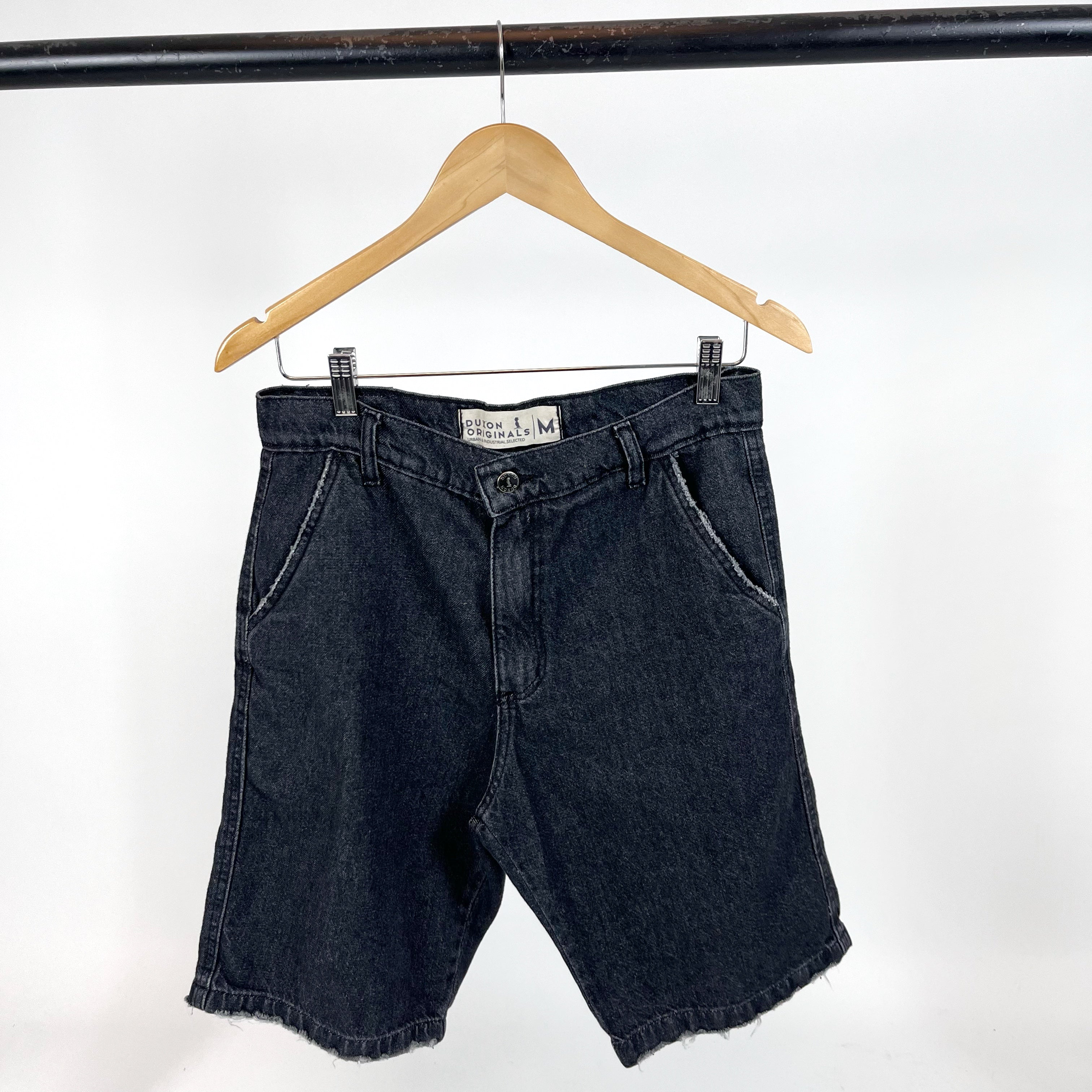 BERMUDA DE JEAN Negro con detalle de rotura en bolsillo y costura.