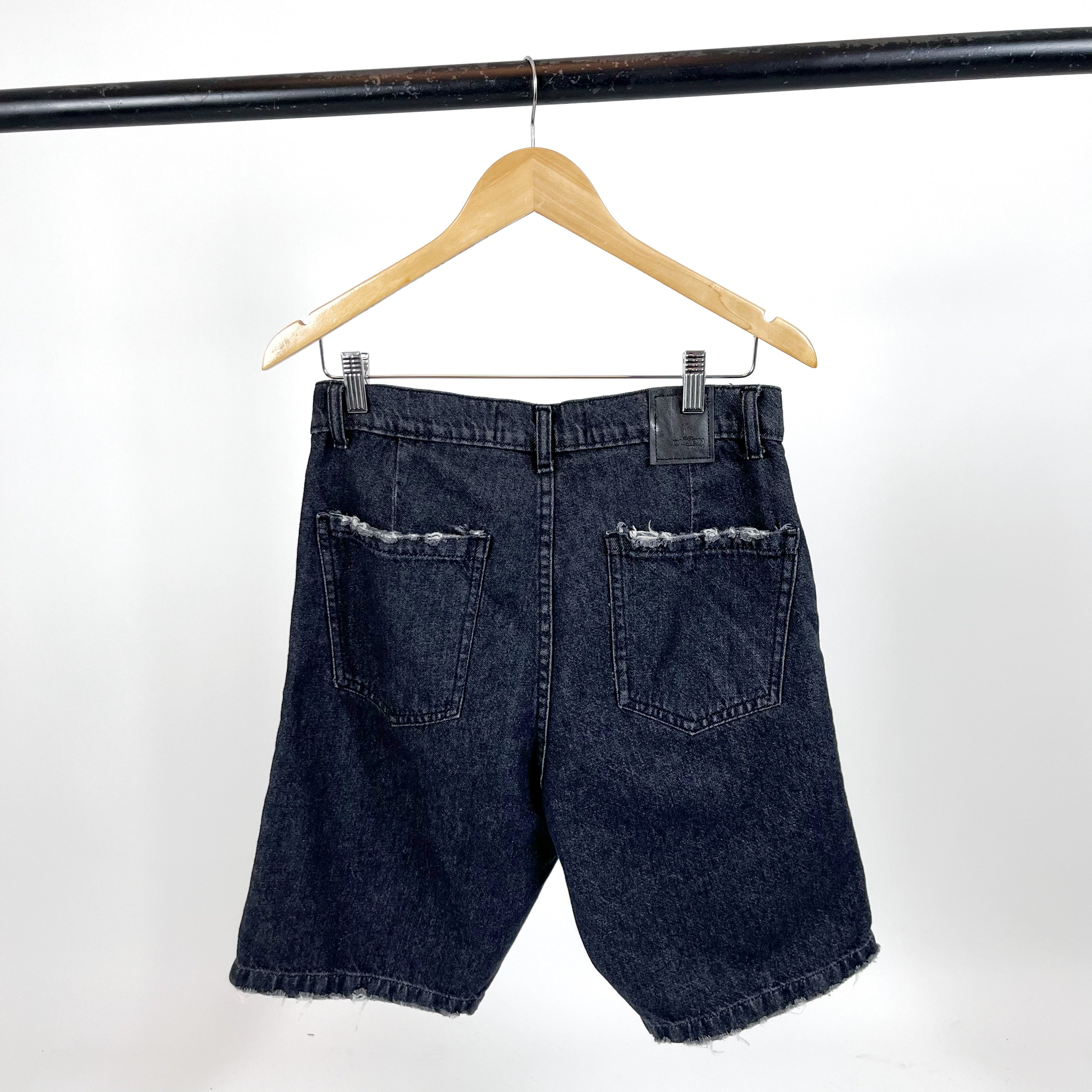 BERMUDA DE JEAN Negro con detalle de rotura en bolsillo y costura.