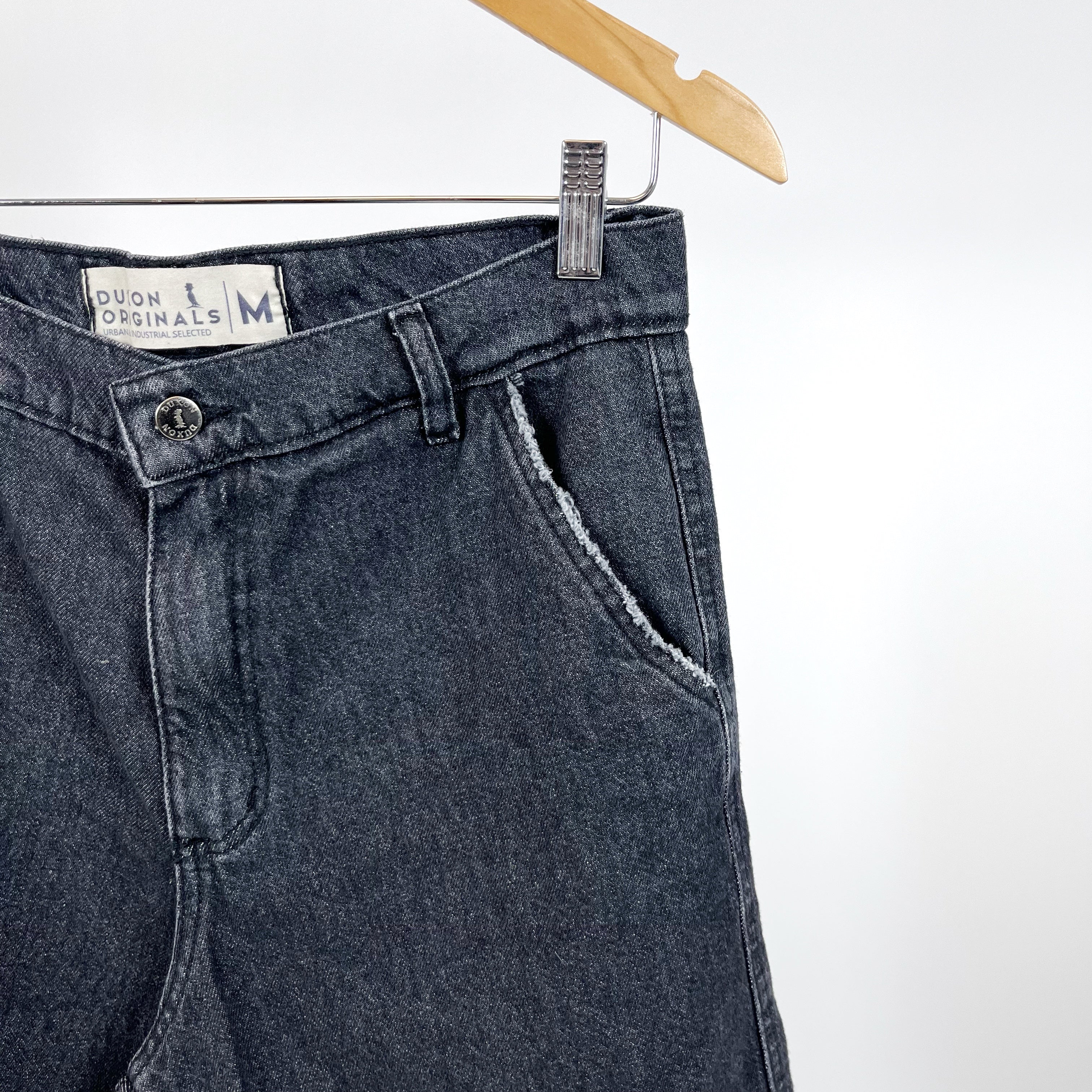 BERMUDA DE JEAN Negro con detalle de rotura en bolsillo y costura.